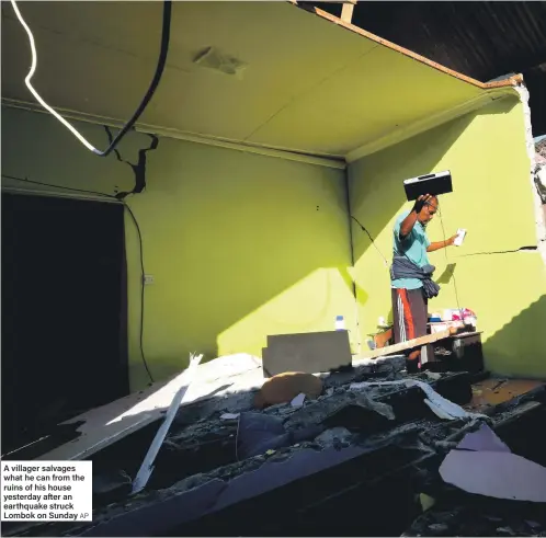  ?? AP ?? A villager salvages what he can from the ruins of his house yesterday after an earthquake struck Lombok on Sunday