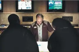  ?? Wally Skalij Los Angeles Times ?? AN EMPLOYEE takes a bet at the Mandalay Bay sports book. Native American tribes have till July 20 to qualify their sports betting measure for the 2022 ballot.