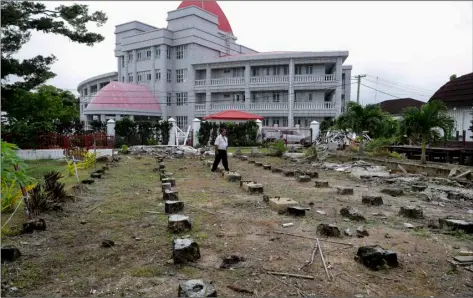  ??  ?? In this April 10 photo, a security guard walks amongst the ruins destroyed last year in Cyclone Gita in Nuku’alofa, Tonga. aP PhoTo/mark Baker