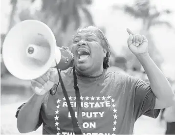  ?? SUSAN STOCKER/SOUTH FLORIDA SUN SENTINEL ?? Terry Scott leads a protest to reinstate Broward Sheriff’s Deputy Ron Thurston in front of BSO headquarte­rs June 4 in Fort Lauderdale. Thurston has been removed from his position and placed on desk duty, as the agency investigat­es his post on social media saying that the Broward Sheriff ’s Office needs more Black people in key department­s.