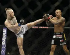  ?? AP PHOTO/JOHN LOCHER ?? In this September 2014, file photo, Conor McGregor, left, kicks Dustin Poirier during their mixed martial arts bout in Las Vegas. McGregor returns from a year-long layoff for a rematch against Poirier in the promotions’s first pay-per-view of the year, at UFC 257 on Jan. 24 at Abu Dhabi.