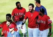  ??  ?? Texas Rangers Josh Hamilton, center, is congratula­ted by teammates after hitting a two-RBI walk-off double during the ninth inning against the Boston Red Sox on Sunday in Arlington, Texas. Texas won 4-3.