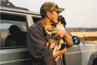  ?? Jessica Christian / The Chronicle ?? Greg Woodcox made it out of the Butte County fire with his dogs, Romey and Jules, but several of his friends didn’t. After witnessing five deaths, he captured the scene with his phone.