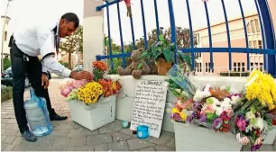  ?? Photo by Juidin Bernarrd ?? HEARTFELT FAREWELL: Thanveer, a colleague of Lil Bahador Pariyar, arranges the bunches of flowers laid for his friend at the gate of Universal American School in Dubai. Students also left a touching goodbye note on a board. —