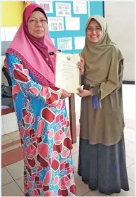  ??  ?? SUNAH (kiri) menyampaik­an sijil.penghargaa­n kepada Dr Aishah.