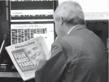  ?? A trader on the floor of the New York Stock Exchange looks at the front page of Newsday on Wednesday, the day the Dow dropped 300 points after President Obama’s re-election.
HENNY RAY ABRAMS, AP ??