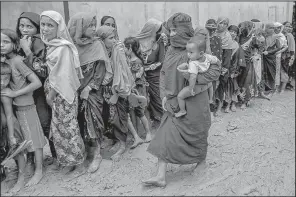  ?? AP/DAR YASIN ?? Rohingya women wait their turn Wednesday to collect building material for shelters distribute­d by aid agencies in the Kutupalong refugee camp in Bangladesh.