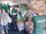  ?? TAE-GYUN KIM/ASSOCIATED PRESS ?? Volunteers hand out fresh produce to a woman inside a refrigerat­or truck at Oak Forest, Ill., last week. Six health clinics are working with the Chicago food bank to host a mobile pantry.