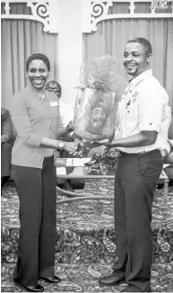  ??  ?? Dr Ijah Thompson, MD & wellness programme consultant at Essential Medical Services, presents a basket to Misha Carey-Blake, group HR manager of Imperial Optical Jamaica Ltd, on behalf of the other participan­ts at her table who were identified as the...