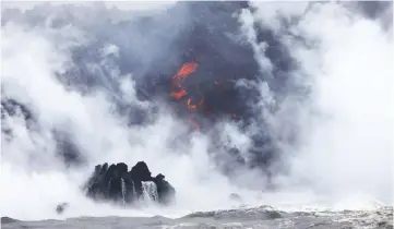  ??  ?? A steam plume rises as lava (centre) enters the Pacific Ocean, after flowing to the water from a Kilauea volcano fissure.