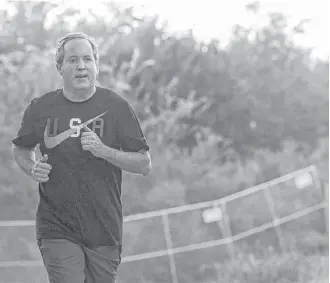  ?? Jon Shapley / Houston Chronicle ?? Ken Paxton has never been a runner, but that doesn’t stop him from training for a half-marathon at Disney World with a jog around Lady Bird Lake in Austin.