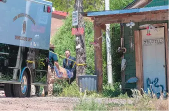  ?? EDDIE MOORE/JOURNAL ?? Officials remove bodies from a home in La Madera on June 16 after three members of a family were slain in the residence. Two other people were later shot to death elsewhere in northern New Mexico, and Damian Herrera, 21, was arrested in the killings.