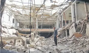  ?? — AFP photo ?? A man stands amidst the rubble at a factory damaged during fighting and air strikes, as clashes recently raged between Yemeni Saudibacke­d government forces and Iran-aligned Huthis.