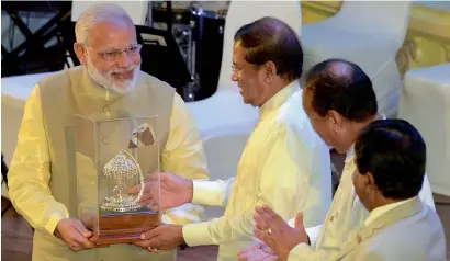  ?? AFP ?? Maithripal­a Sirisena presents a memento to Narendra Modi during an internatio­nal Buddhist conference in Colombo on Friday. —