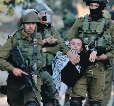  ?? JAAFAR ASHTIYEH / AFP / GETTY IMAGES ?? Israeli security forces arrest a Palestinia­n protester in the Israeli-occupied West Bank this week as protests continue in the region amid anger over U.S. President Donald Trump’s recognitio­n of Jerusalem as its capital.