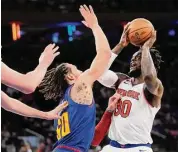  ?? Mary Altaffer/Associated Press ?? The Knicks forward Julius Randle (30) goes to the basket as the Nuggets’ Aaron Gordon (50) defends on Saturday at Madison Square Garden in New York.