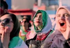  ??  ?? Donne tifose dell’Iran e avvolte dalla bandiera nazionale