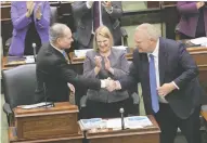  ?? NATHAN DENETTE / THE CANADIAN PRESS ?? Minister of Finance Peter Bethlenfal­vy, left, shakes hands
with Premier Doing Ford, right, as Health Minister Sylvia Jones looks on during Tuesday's budget speech.