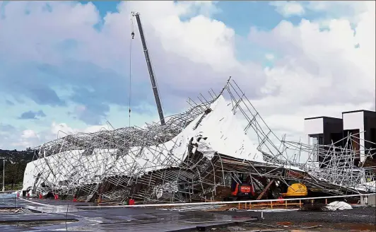  ??  ?? Stormy devastatio­n: Damaged scaffoldin­g being cleared in Auckland’s Hobsonvill­e Point after the storm hit the region. — AFP