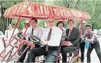  ??  ?? 陳瑞榮（左起）和關和貴親自騎駛四人­腳車載送曾憲源夫婦。