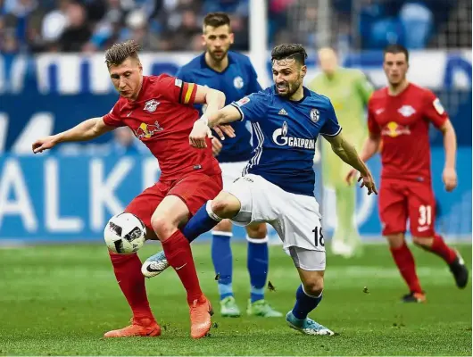  ??  ?? No you don’t: RB Leipzig’s Willi Orban (left) vying for the ball with Schalke’s Daniel Caligiuri in the Bundesliga match in Gelsenkirc­hen on Sunday. The match ended 1-1. — AP