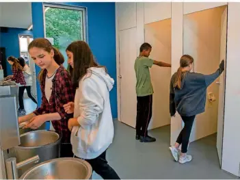  ?? FOTO: STEFAN PUCHNER/DPA ?? Jungen und Mädchen in der Unisex-Toilette an der Sägefeldsc­hule in Ulm. Das neue Klo, für das die Geschlecht­er-Trennung nach der Sanierung aufgehoben wurde, verfügt nur über Kabinen – die Pissoirs sind passé.