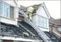  ?? Picture: Gary Browne ?? Firefighte­rs inspecting the roof after the blaze