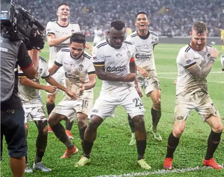  ??  ?? I’m back!: Terengganu’s Kipre Tchetche (centre) found his goalscorin­g touch during their Super League match against Felda United on Friday.