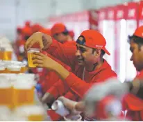  ?? PETR DAVID JOSEK/ASSOCIATED PRESS FILE PHOTO ?? A staff member holds a beer in a fan zone ahead of a World Cup match in Doha, Qatar. The country heavily restricts alcohol sales and consumptio­n.