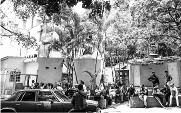  ?? — AFP photo ?? Relatives of those killed in the night club ‘Los Cotorros’ – where a tear gas grenade was detonated – wait outside the morgue in Caracas.