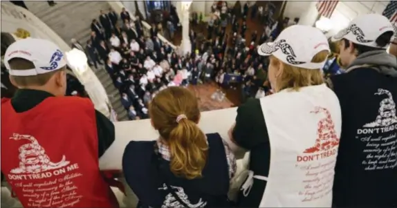  ?? MARC LEVY — THE ASSOCIATED PRESS ?? People watch as supporters of gun rights crowd carrying concealed weapons. the Capitol rotunda in Harrisburg, Pa., on Monday pushing for an agenda that includes looser rules for