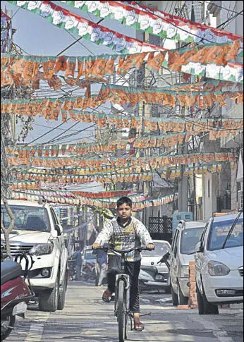  ?? GURPREET SINGH/HT ?? A boy riding a bicycle under the maze of buntings hung by candidates of various parties in Ludhiana on Thursday.
