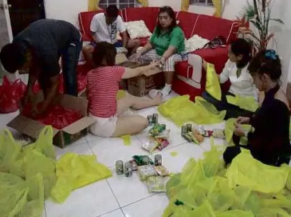  ?? CONTRIBUTE­D PHOTO ?? JOCELYN Hernandez (center) packs relief goods in her house in Bacoor City in Cavite, briefly setting aside her own battle against a kidney abnormalit­y.