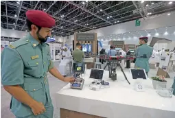  ?? — Photos by Dhes Handumon ?? A drone on display at the Sharjah Pavilion, right, Ali Salem Al Midfa, chairman, Sharjah Int’l Airport, and other officials at the 37th Gitex Technology Week.