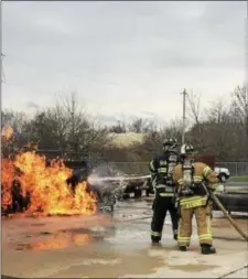  ?? GINGER RAE DUNBAR — DIGITAL FIRST MEDIA ?? Delaware County Technical High School student Robert Root, left, put out a car fire, with assistance from mentoring firefighte­r Shawn Evans. Vo-Tech students participat­ed in various emergency scenarios held Friday the training center. at