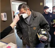  ?? MATT sTonE phoTos / hErAld sTAff ?? TEMP CHECK: Norwell Fire Capt. Bill Milne gets his temperatur­e taken at the Royal Health Group before getting vaccinated Wednesday in Norwell. At right, Norwell Chief Jeff Simpson gets his COVID-19 vaccine.