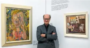  ?? — AFP ?? Rare works: Warhola standing next to Warhol’s ‘Nosepicker 1: Why Pick on Me’ and ‘Living Room’ on display in New York.