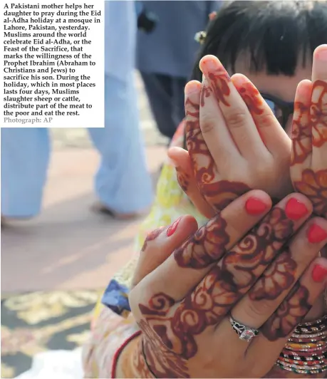  ?? Photograph: AP ?? A Pakistani mother helps her daughter to pray during the Eid al-Adha holiday at a mosque in Lahore, Pakistan, yesterday. Muslims around the world celebrate Eid al-Adha, or the Feast of the Sacrifice, that marks the willingnes­s of the Prophet Ibrahim (Abraham to Christians and Jews) to sacrifice his son. During the holiday, which in most places lasts four days, Muslims slaughter sheep or cattle, distribute part of the meat to the poor and eat the rest.