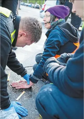  ?? ?? Climate activists often voluntaril­y glue themselves to streets, which has resulted in police coming up with creative ways to unglue them without injuring them.