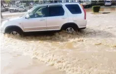  ?? – Picture: Admire Chitsungo ?? A motorist drives in a pool of water at Kadoma’s Cameroon Square following rains that resulted in flash floods in the city due to blocked drainage systems yesterday.
