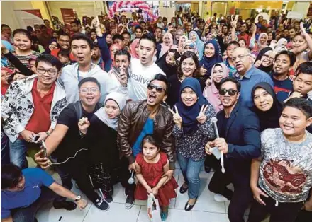  ?? BY MUHD ZAABA ZAKERIA
PIC ?? Singer-cum-songwriter Faizal Tahir (centre with sunglasses) with fans in Subang Jaya on Sunday.