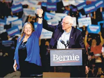  ?? Dania Maxwell Los Angeles Times ?? SEN. BERNIE SANDERS and his wife, Jane, arrive onstage during a downtown rally on Sunday evening at the Los Angeles Convention Center, a campaign event that drew an estimated crowd of more than 15,000.