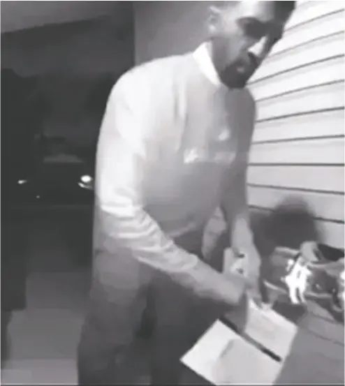  ?? COURTESY GLENN PENNETT ?? Calgary Skyview MP George Chahal caught on camera removing an opponent’s campaign flyer.