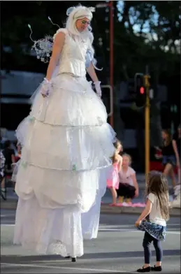  ?? ZHOU DAN / XINHUA ?? An actor dressed as giant fairy entertains a small girl during a Christmas parade in Perth, Australia, on Saturday.