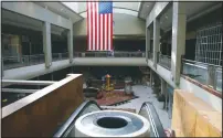  ??  ?? A U.S. flag hangs inside the now-defunct Metrocente­r mall in Phoenix on March 14. In the 1980s as the Phoenix area expanded, the mall’s decline began as many of the immediate residentia­l neighborho­ods bordering Metrocente­r as middle-class residents moved away.