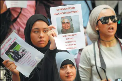  ?? TOBY MELVILLE / REUTERS ?? Demonstrat­ors hold up missing persons posters during a protest outside Kensington Town Hall, following the fire that destroyed the Grenfell Tower block, in north Kensington, London, United Kingdom, on Saturday.