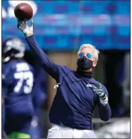  ?? (AP/Ted S. Warren) ?? Seattle Seahawks Coach Pete Carroll throws a pass Wednesday during the Seahawks’ training camp in Renton, Wash. The NFL has implemente­d health protocols to help teams combat covid-19.