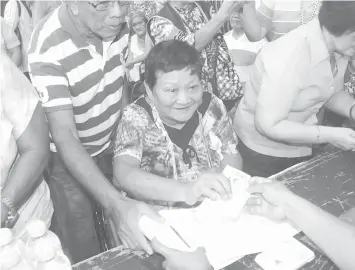  ?? FILE PHOTO ?? In this file photo, an elderly woman receives cash assistance from the city government of Mandaue. Mayor Gabriel Luis “Luigi” Quisumbing wants all 100-years-old in the city to get P100,000 birthday gift.