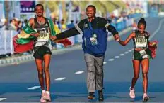  ?? AFP ?? Ethiopian runners Worknesh Degefa and Tamirat Tola celebrate after winning the Dubai Marathon women’s and men’s race yesterday.