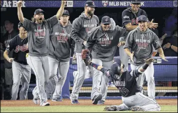  ?? CHARLIE RIEDEL / AP ?? Indians teammates prepare to mob kneeling first baseman Carlos Santana after his final catch in the ALCS clincher against the Blue Jays on Wednesday.